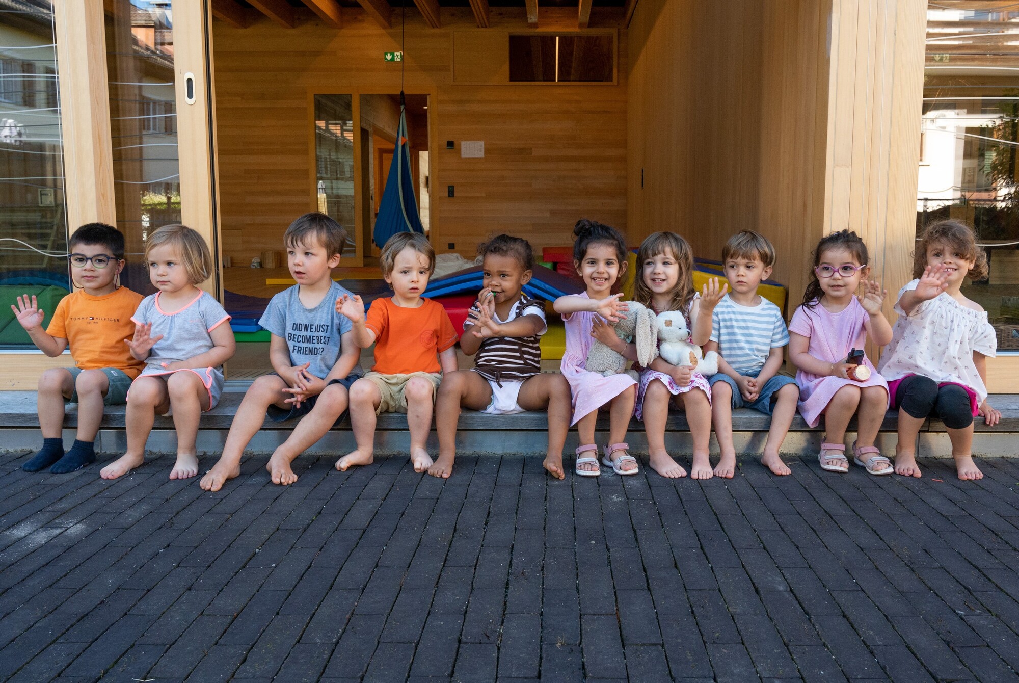 winkende Kinder vor dem Kinderhaus, Elementarpädagogik