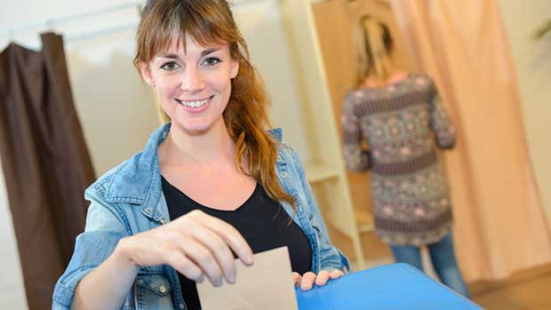 Frau wirft Briefumschlag in Wahlurne