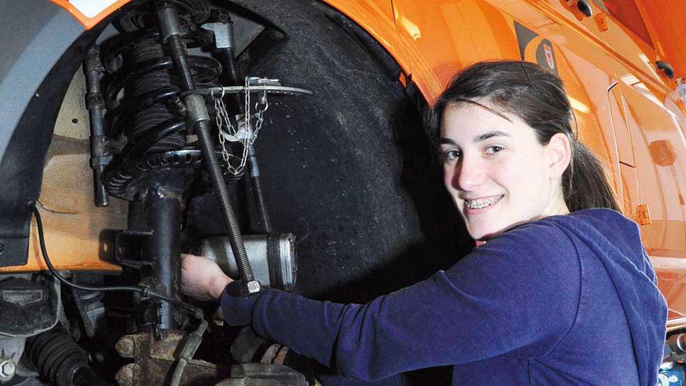 Junge Frau repariert Fahrzeug