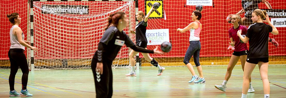 Landesrätin Martina Rüscher beim Handballspiel mit Arbeitskollegin und Handballspielerinnen